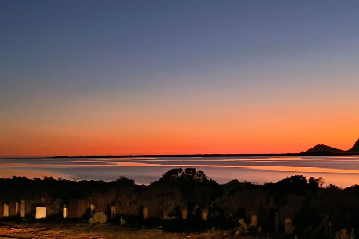 A scenic sunset view overlooking the water and distant landscape, showcasing the natural beauty and tranquil setting of the residential land.