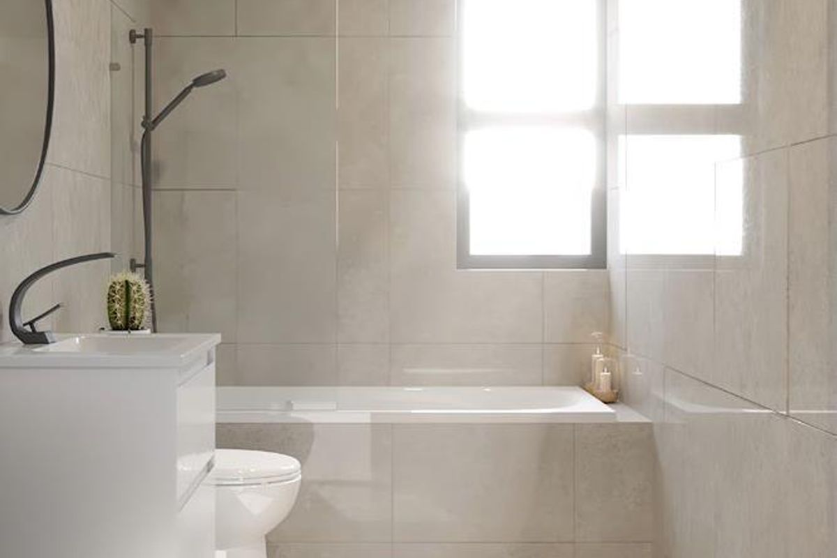 Modern bathroom featuring a built-in bathtub, wall-mounted shower, vanity with basin, and toilet, finished with neutral wall and floor tiles.