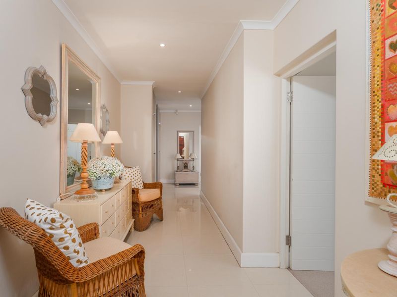 A bright and well-maintained hallway featuring neutral tiled flooring, recessed downlighting, and clean architectural finishes throughout the corridor.