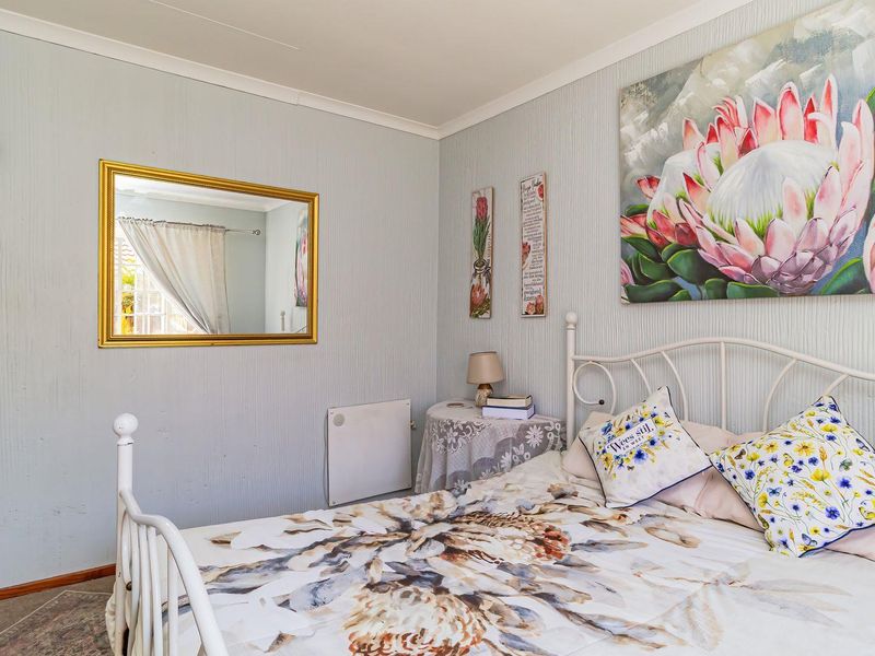 A cozy bedroom featuring textured wallpaper, coving, and a wall-mounted electric heater, providing a comfortable and functional living space.