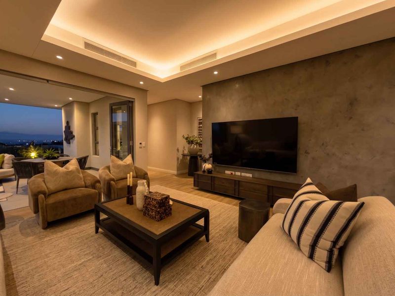 Modern living room featuring a textured feature wall, recessed cove lighting, and seamless access to an outdoor patio area.