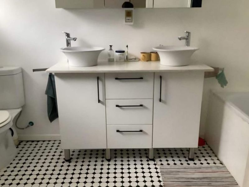 Bathroom featuring a modern double vanity with vessel sinks, chrome fixtures, and classic black and white patterned floor tiles.