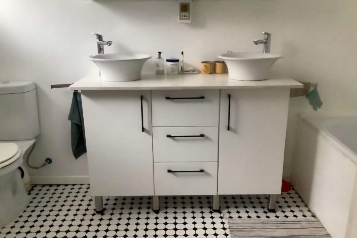 Bathroom featuring a modern double vanity with vessel sinks, chrome fixtures, and classic black and white patterned floor tiles.