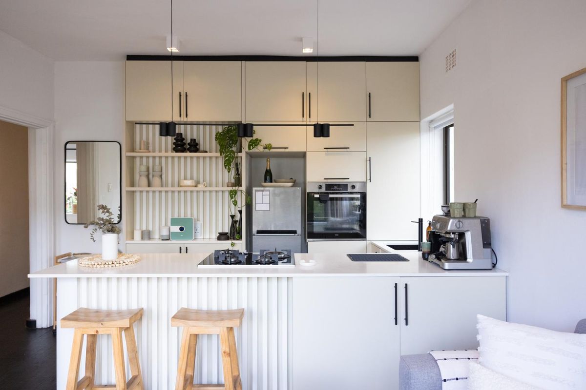 Modern kitchen featuring sleek cabinetry, stone countertops, integrated shelving, and a built-in gas cooktop with oven, creating a functional and stylish culinary space.