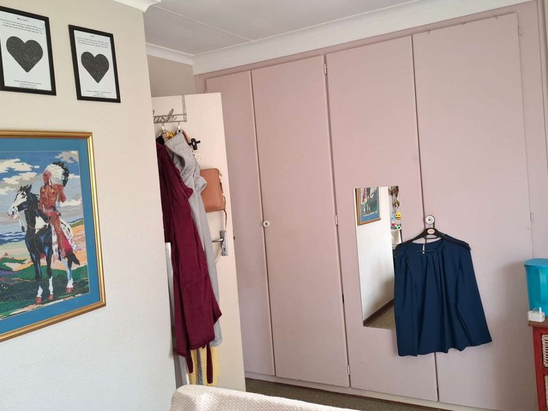A bedroom featuring built-in cupboards with a neutral finish and coved ceiling detailing.