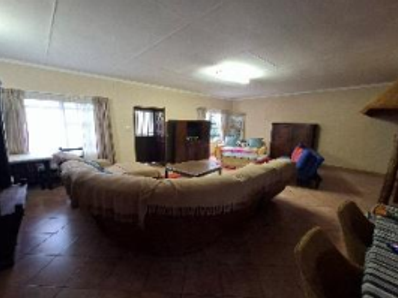 Spacious living room featuring tiled flooring, coved ceilings, and a built-in fireplace, offering a functional layout for family relaxation.