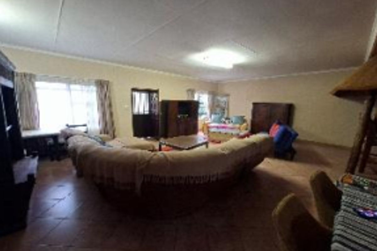 Spacious living room featuring tiled flooring, coved ceilings, and a built-in fireplace, offering a functional layout for family relaxation.