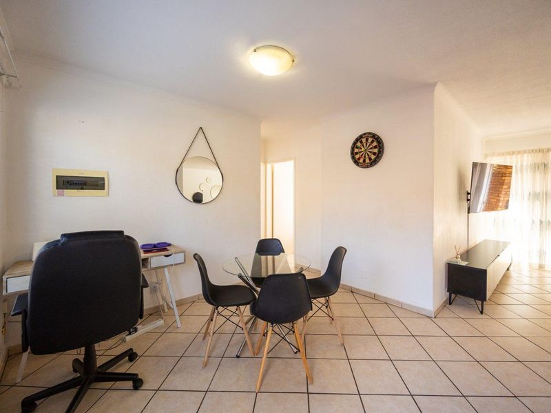 Open-plan living area featuring tiled flooring, neutral walls, and a sliding glass door providing access to the exterior.