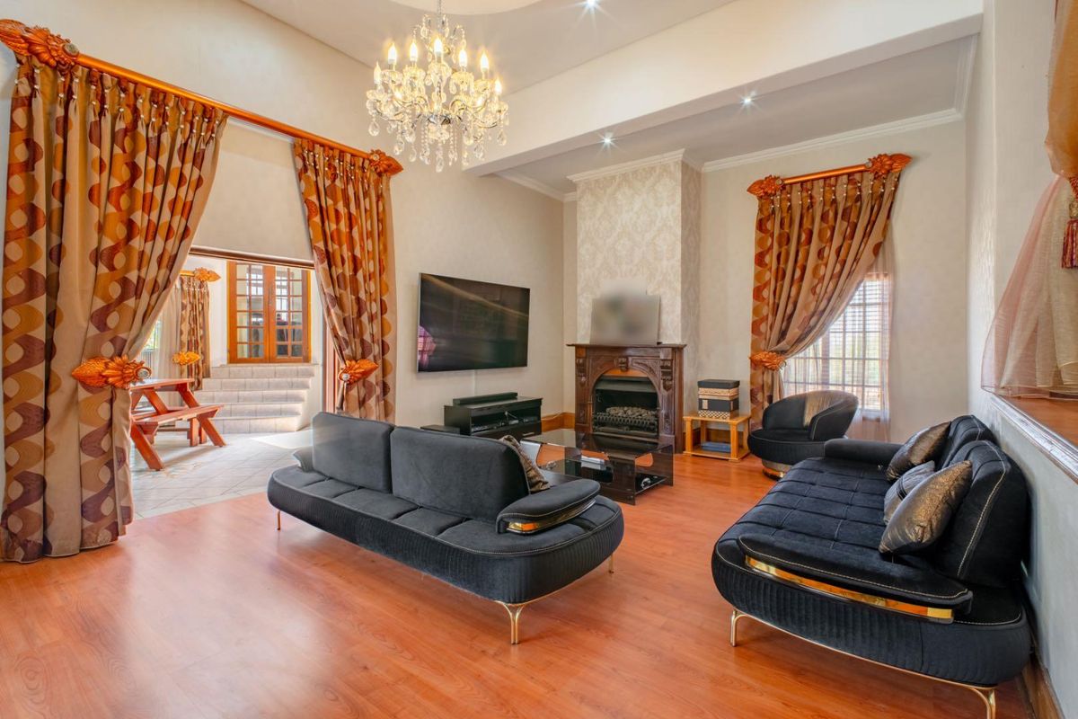 Spacious living room featuring high ceilings, a classic fireplace with decorative surround, and direct access to an outdoor patio area.