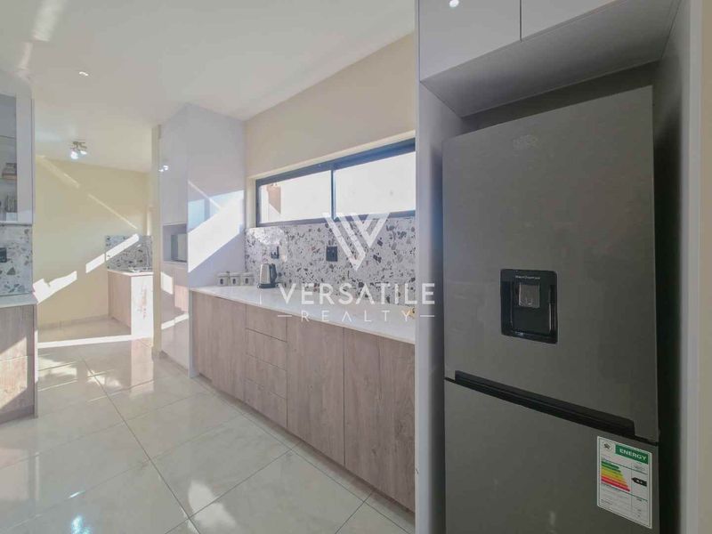 Modern kitchen featuring sleek built-in cabinetry, a stylish terrazzo-style backsplash, and high-quality tiled flooring, offering a clean and contemporary culinary space.