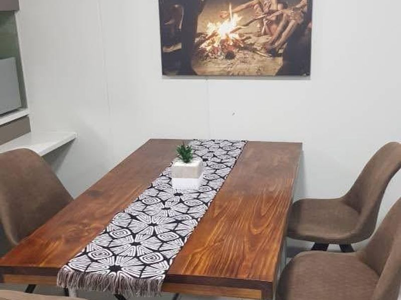 A dining area featuring tiled flooring and a neutral wall finish, providing a clean and functional space for meals.