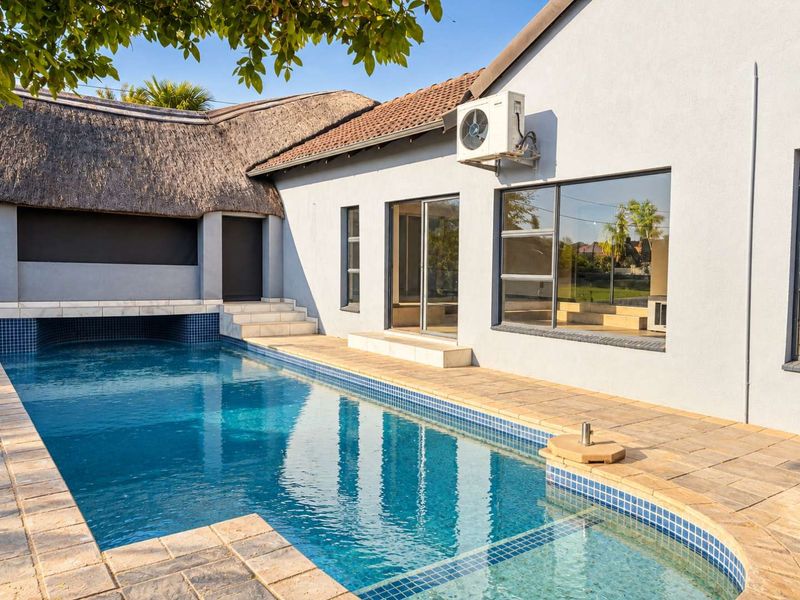 A well-maintained outdoor pool area featuring a tiled surround, integrated swimming pool, and direct access to the home via sliding glass doors.