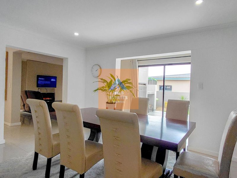 Bright dining area featuring tiled flooring, recessed downlighting, and a sliding glass door providing direct access to the outdoor patio area.