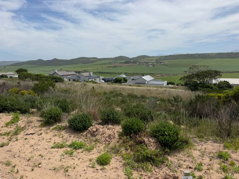 A scenic view overlooking a vacant residential plot with surrounding hills and rural landscape.