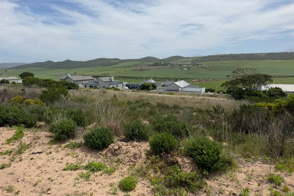 A scenic view overlooking a vacant residential plot with surrounding hills and rural landscape.
