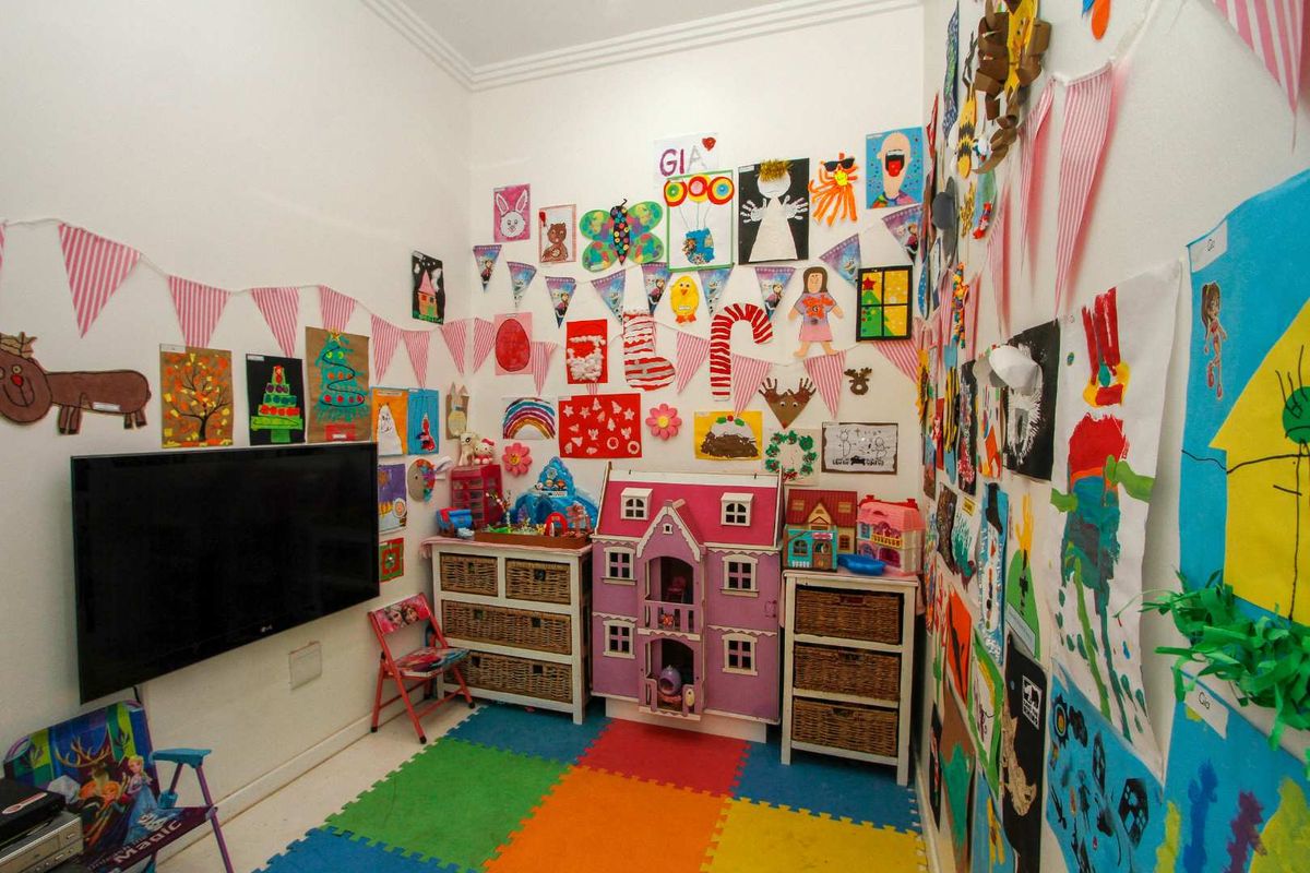 A versatile bedroom or play area featuring neutral walls and a durable floor surface, suitable for various family uses.