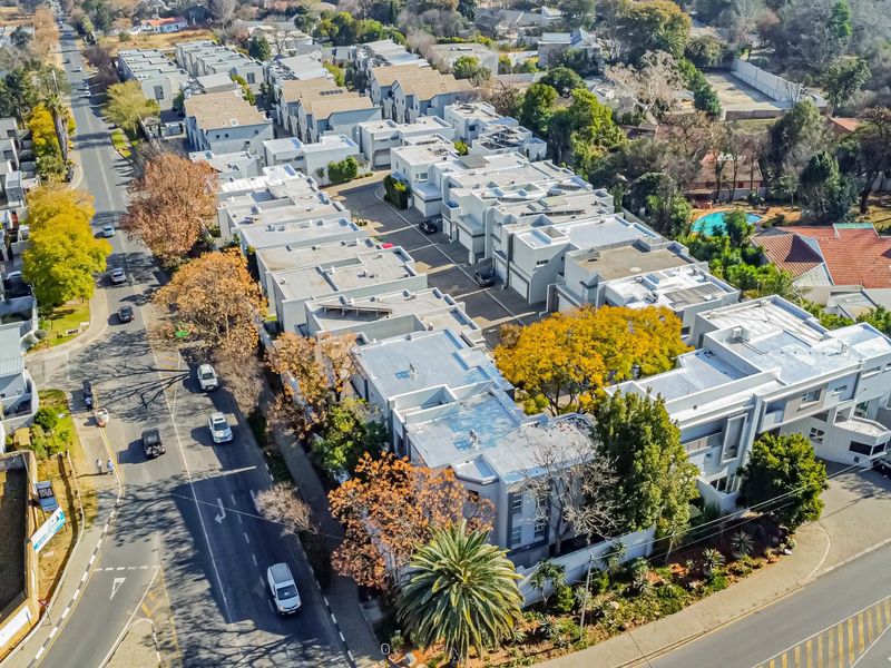 An aerial view of a residential apartment complex showing the layout of multiple units, internal roads, and surrounding neighborhood infrastructure.
