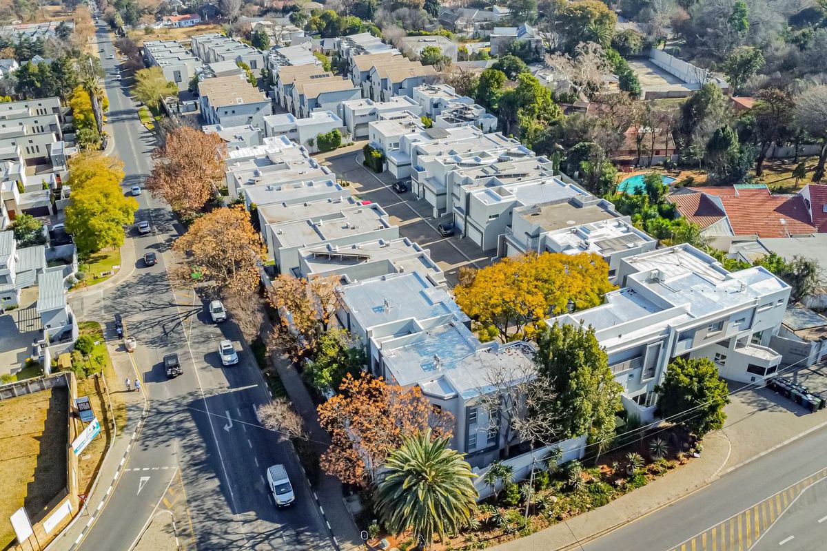 An aerial view of a residential apartment complex showing the layout of multiple units, internal roads, and surrounding neighborhood infrastructure.