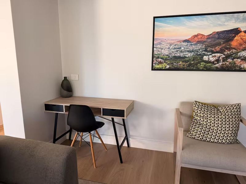 A well-maintained living area featuring light-toned laminate flooring, neutral wall finishes, and modern skirting boards.