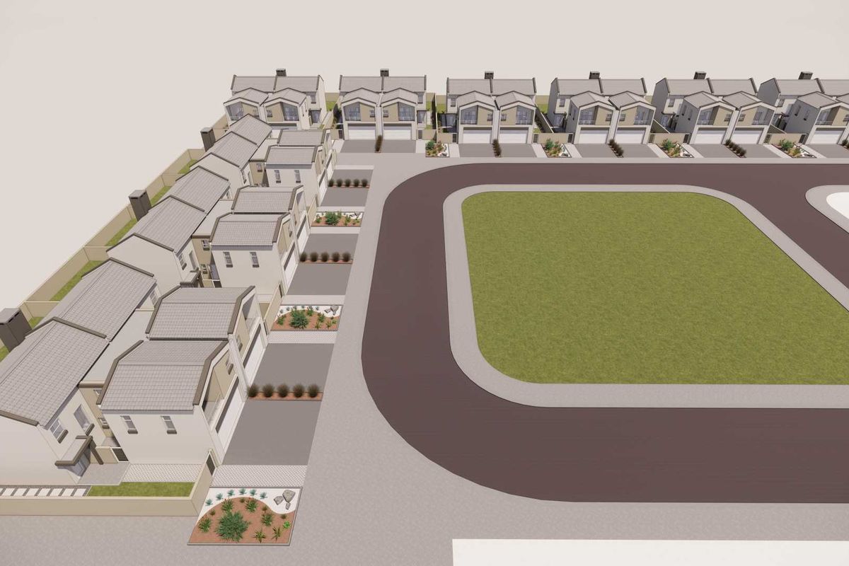 An aerial view of a townhouse complex featuring multiple units with tiled roofs, paved driveways, and a central communal lawn area.