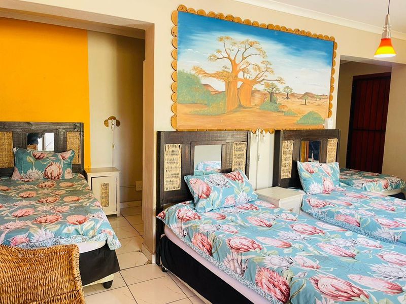 A bedroom featuring tiled flooring, cove cornicing, and a pendant light fixture, currently configured with multiple beds.