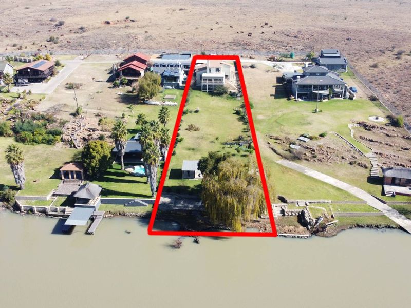 Aerial view of a large waterfront property plot, highlighting the expansive garden area, direct water access, and the main dwelling location.