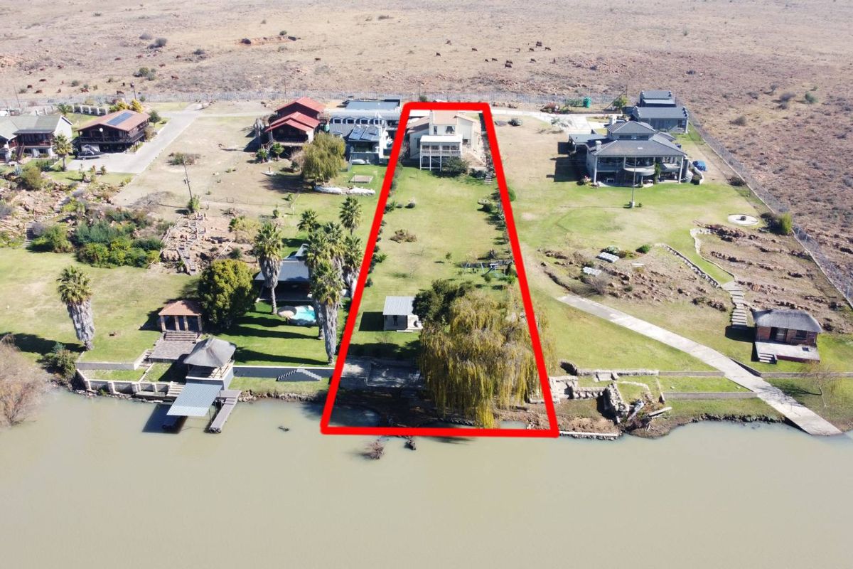 Aerial view of a large waterfront property plot, highlighting the expansive garden area, direct water access, and the main dwelling location.