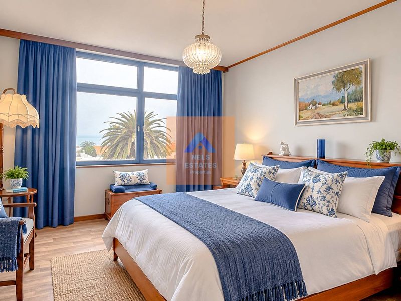 A well-maintained bedroom featuring large windows with natural light, laminate flooring, and classic timber trim details.