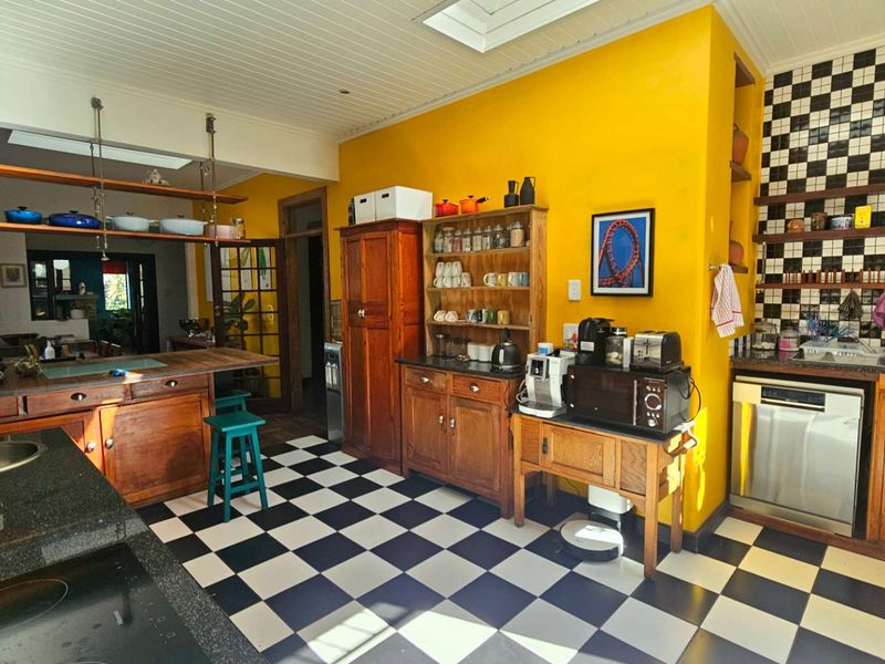 A characterful kitchen featuring wooden cabinetry, granite countertops, a checkerboard tiled floor, and a skylight, offering a unique and warm aesthetic.