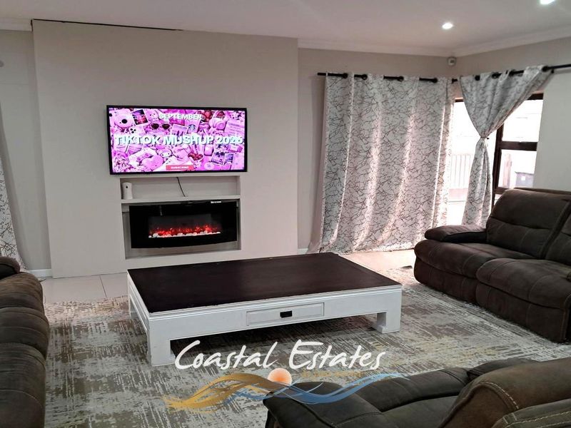 A comfortable living room featuring a modern recessed fireplace, tiled flooring, and sliding glass doors that provide access to the exterior.