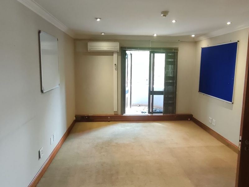 A vacant office space featuring carpet flooring, recessed lighting, an air conditioning unit, and a sliding door leading to an outdoor area.