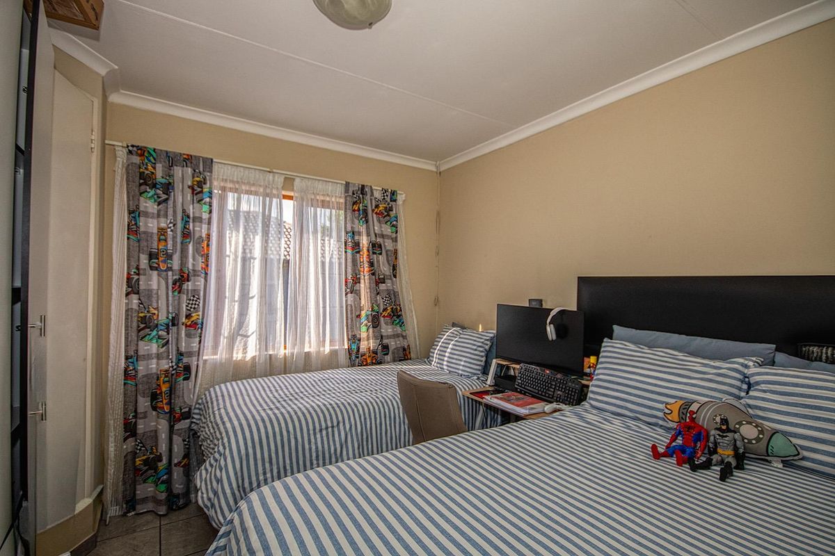 A functional bedroom featuring built-in cupboards and tiled flooring, providing a practical space for rest and storage.