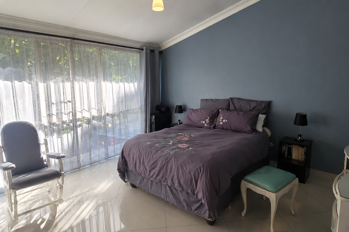 A spacious bedroom featuring large sliding glass doors that provide ample natural light and direct access to the exterior.