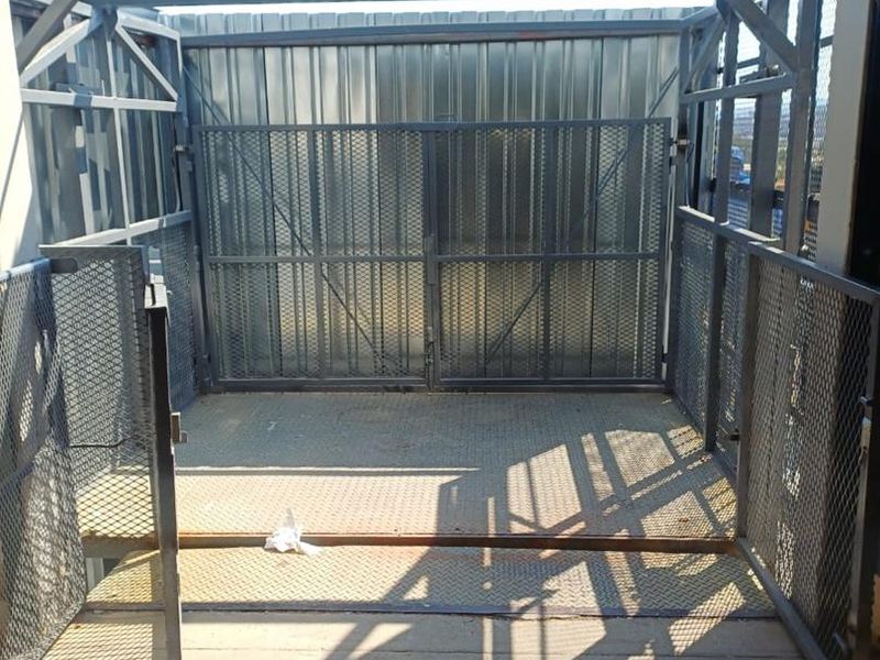 A secure industrial utility space featuring heavy-duty metal mesh gates, steel framing, and durable diamond plate flooring.