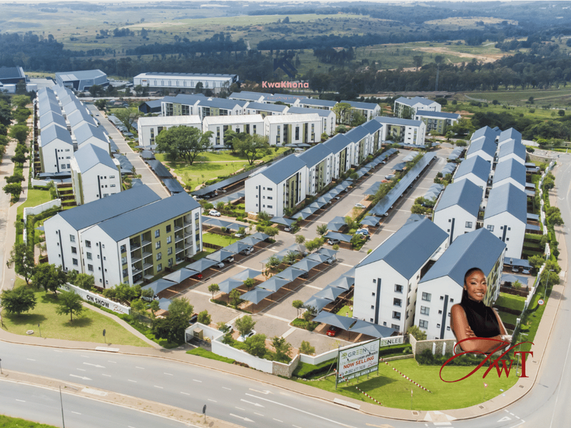 Aerial view of a modern residential apartment complex featuring multiple blocks, covered parking bays, and landscaped communal grounds.