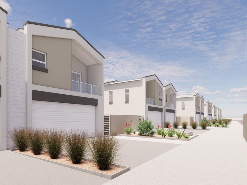 A row of modern townhouse units featuring garages, upper-level balconies with glass balustrades, and neat landscaped front garden beds.