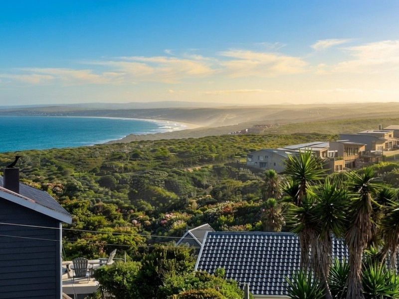 A scenic elevated view overlooking the coastal landscape, ocean, and surrounding residential estate.