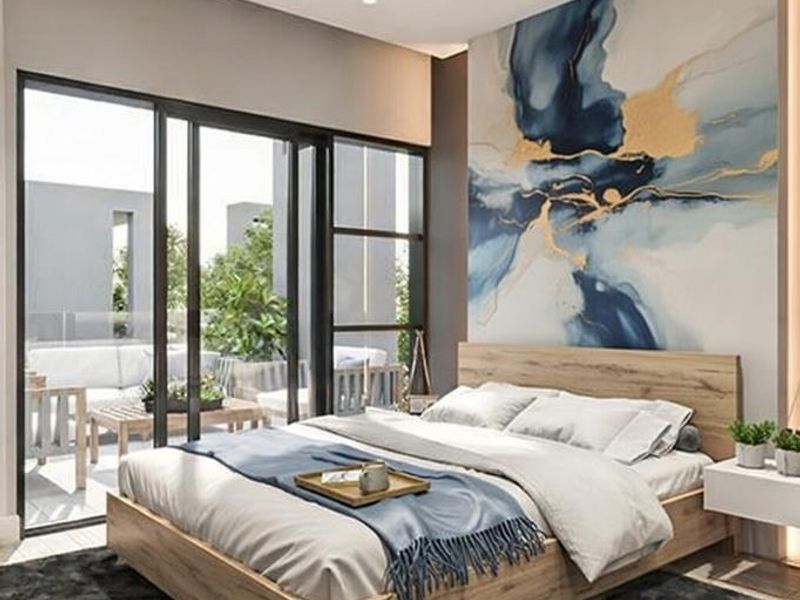 Modern bedroom featuring a large feature wall, recessed lighting, and floor-to-ceiling sliding glass doors providing access to an outdoor patio area.