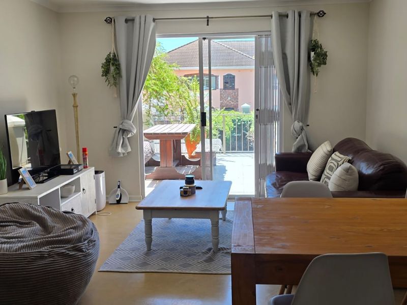 Open plan living and dining area featuring tiled flooring and a large sliding glass door providing access to an outdoor patio space.