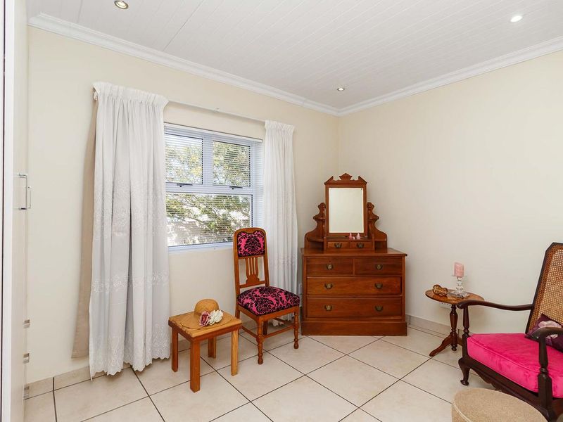 A well-maintained bedroom featuring tiled flooring, a tongue and groove ceiling with recessed lighting, and a built-in cupboard.