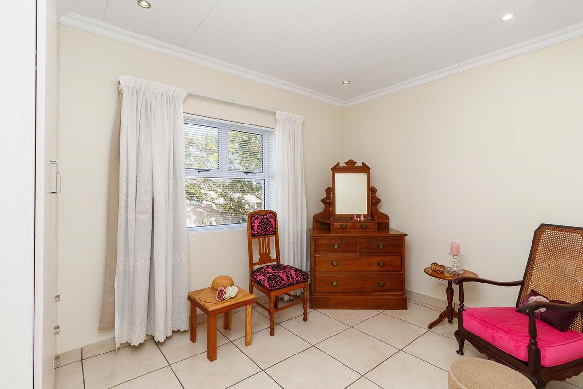 A well-maintained bedroom featuring tiled flooring, a tongue and groove ceiling with recessed lighting, and a built-in cupboard.