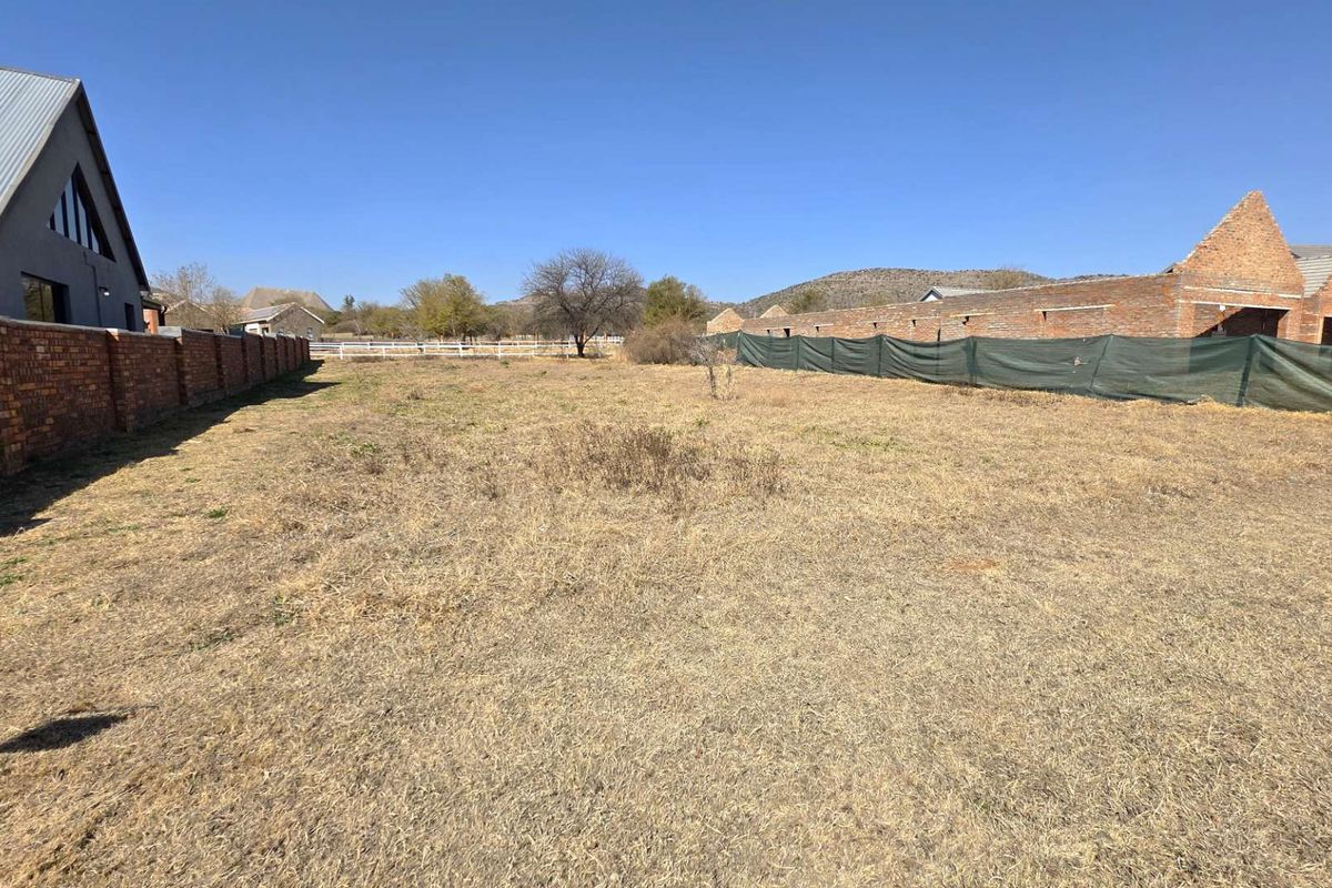 A vacant residential plot featuring established brick boundary walls and temporary shade cloth fencing, offering a clear space for future development.