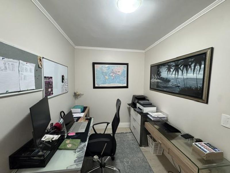 A functional home office space featuring neutral wall finishes, coving, and practical layout suitable for a dedicated workspace.