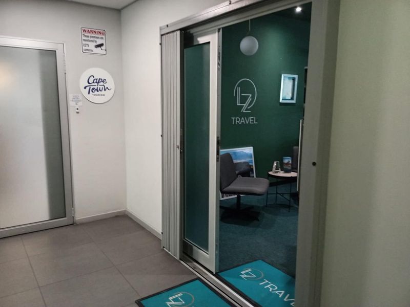 A professional office space featuring a sliding glass entrance, tiled flooring, and modern interior finishes suitable for a corporate environment.