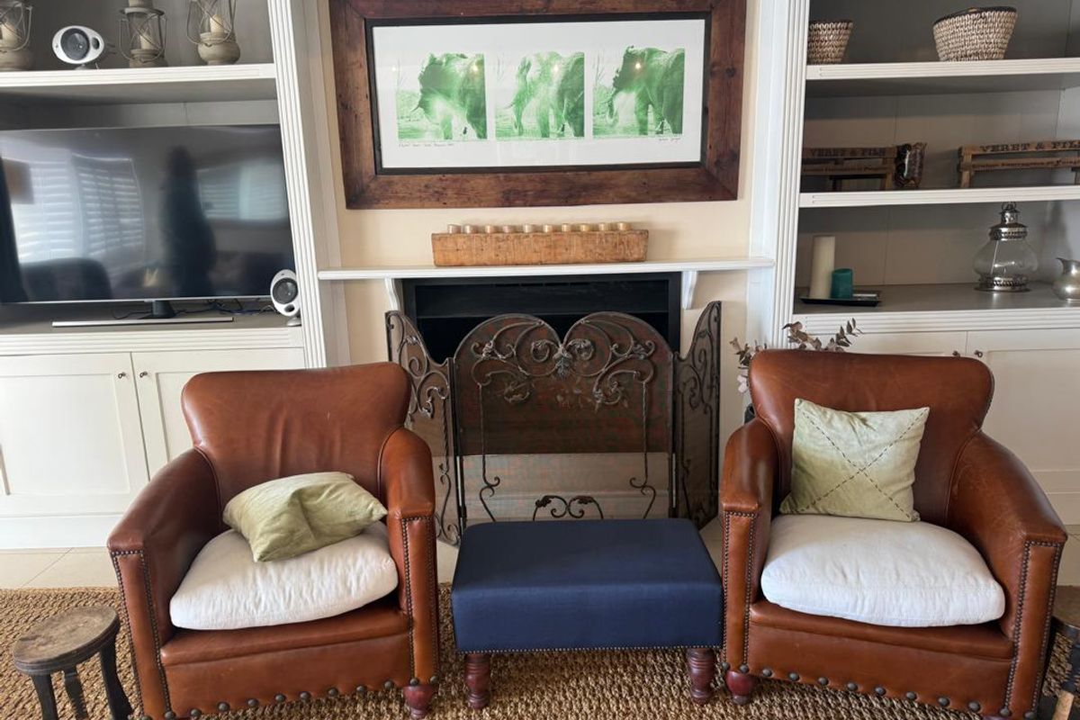 A cozy living room area featuring a built-in fireplace with surrounding custom cabinetry and shelving units.
