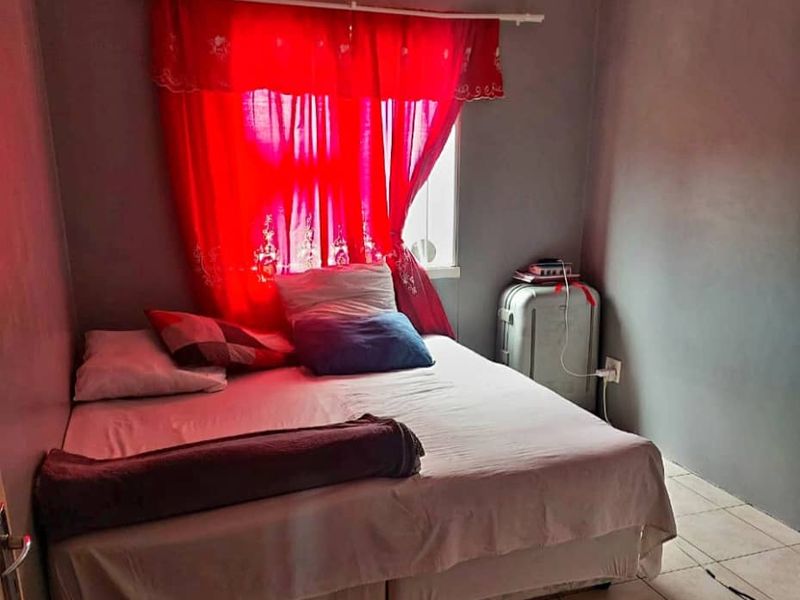 A compact bedroom featuring tiled flooring and neutral wall finishes, offering a functional space ready for cosmetic updates.
