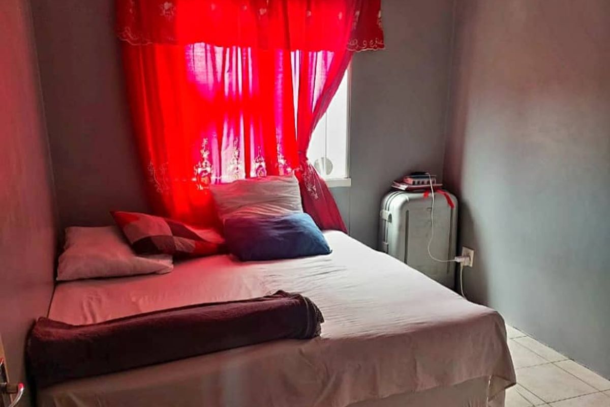 A compact bedroom featuring tiled flooring and neutral wall finishes, offering a functional space ready for cosmetic updates.