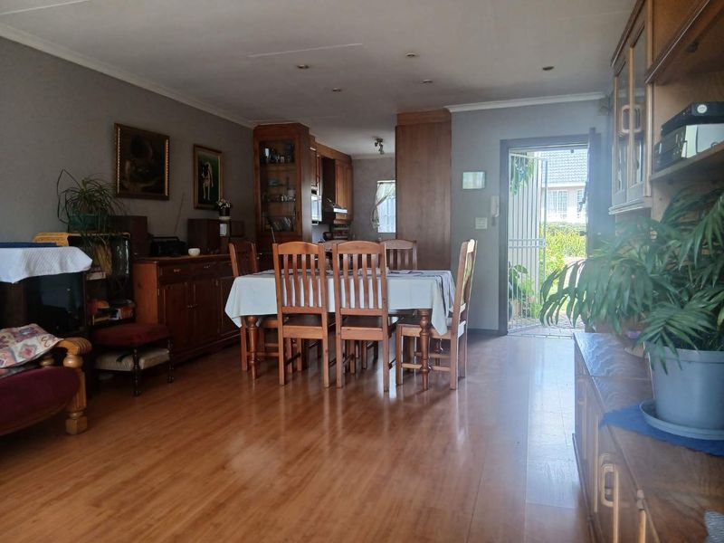 Open plan living and dining area featuring laminate flooring, recessed lighting, and direct access to the exterior through a security gate.