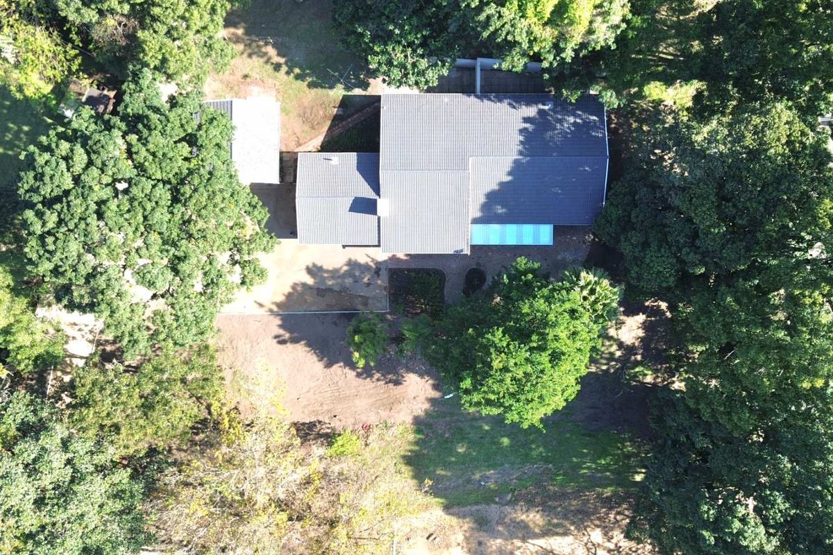 Aerial view of the townhouse property showing the roof structure, surrounding mature trees, and the garden area.