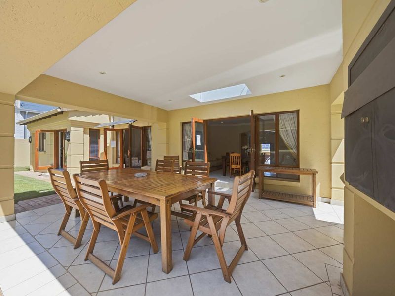 Spacious covered patio featuring tiled flooring, recessed lighting, a skylight, and a built-in braai, providing an ideal space for outdoor entertaining.